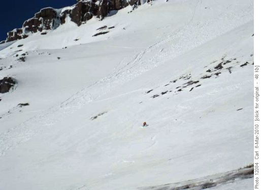 Skiing down on safe terrain near a one hour old slide