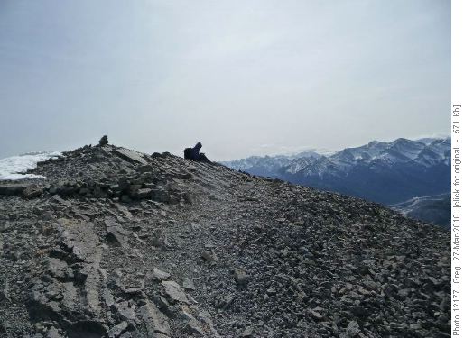 A moment of reflection in the summit wind and clear sky
