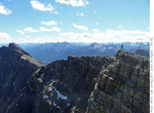 Ridge between center peak (foreground) and south peak (left). Assiniboine behind Brett in center of photo.