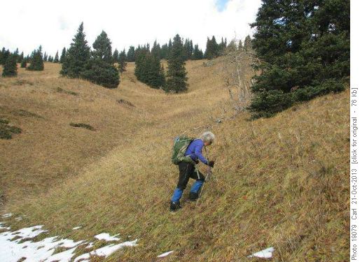 Carolyn starts up grassy slope to ridge