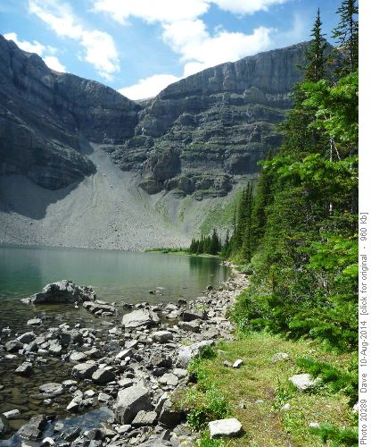 Lake with hikers on sky line going to top of mountain