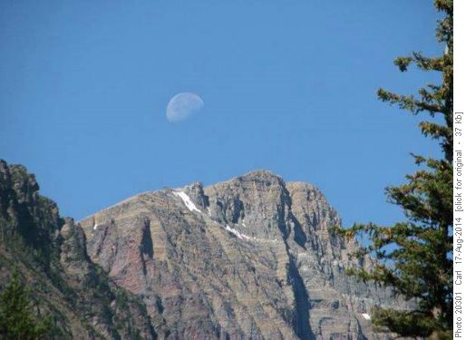 Moonset over the peak in clear blue sky
