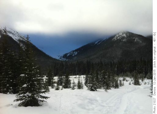 Blue reflections on mountain below low cloud