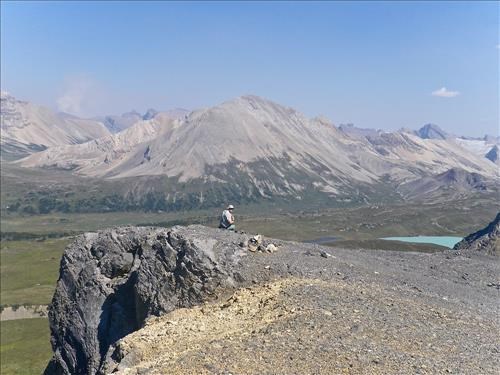 Terry on Quartzite Ridge overlooking Drommond Icefield, Palliser Pass, Clearwater Pass, upper reaches of Siffleur River and smoke from a forest fire