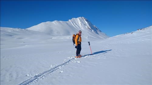 Dave stops for a rest during trail breaking. Mount Wilcox in the back