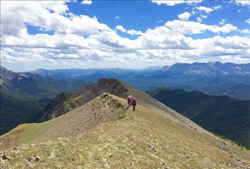 Leaving the summit back along the ridge. Our lunch stop was the lowest dip in a cloud shadow.