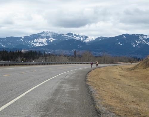 Cycling toward peaks of the Highwood under a grey sky.