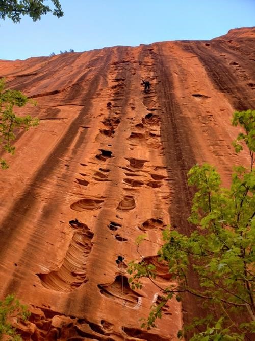Rock climber high on the canyon wall