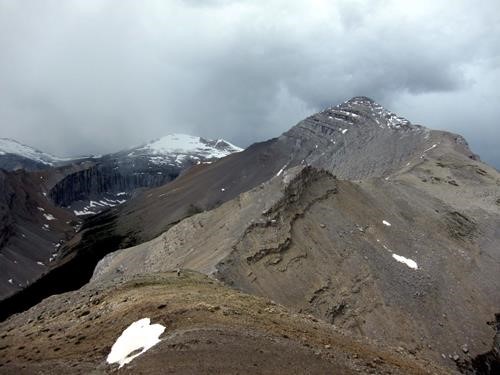 Descent to the col with brooding storm clouds (photo courtesy Bill)