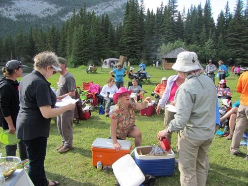 {466 Eala West} (pink hat) hands out the food while Karen D. (left) checks the name off the list