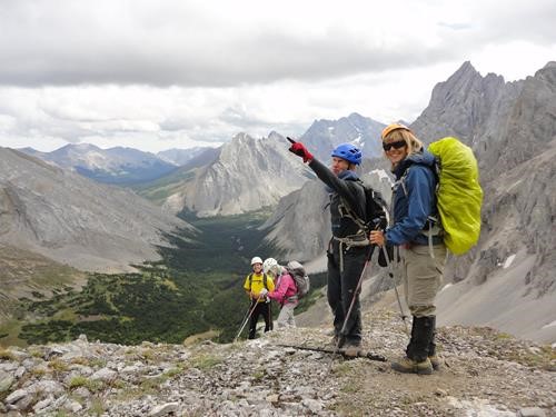 {1288 b pi}, {168 si gal}, {1501 br ram} and {1964 ka fr} on bench of Mt.Schlee. Elbow Lake trail and Mt.Elpoca behind