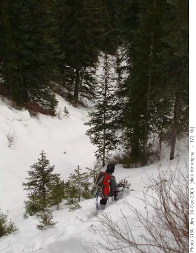 Greg cautiously picks his way down a steep snow covered ravine.