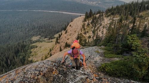 Suzy scrambling over a bump, Yellowhead Hwy below.