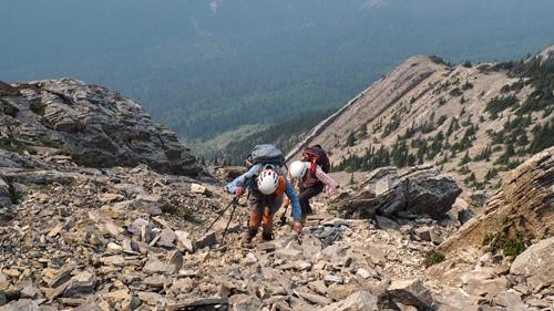 Christine G and Shirley pick their way up loose rock.