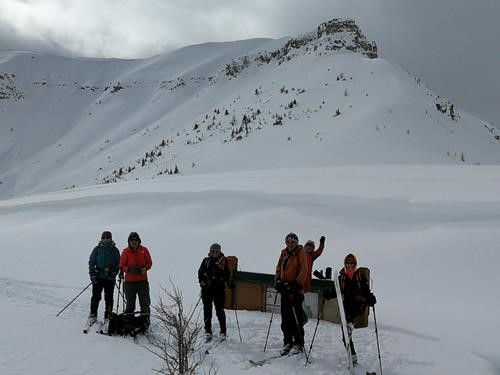 Group standing in front of the infamous nearly buried Citadel Pass Parks Canada sign