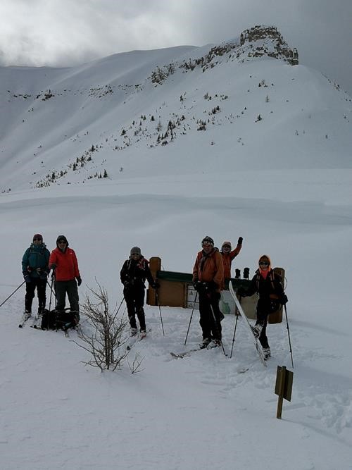 Group standing in front of the infamous nearly buried Citadel Pass Parks Canada sign