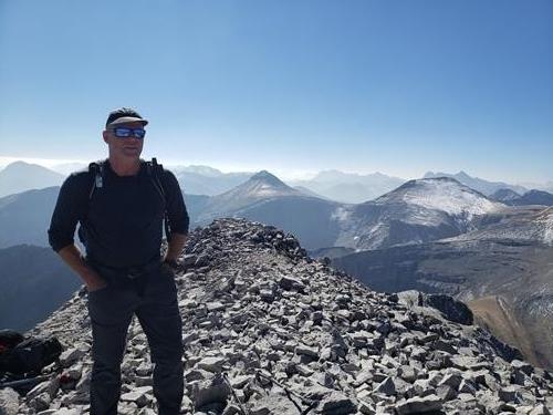 Simon on the summit of Mount Glasgow, Outlaw and Banded in the background