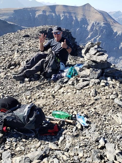 Simon on the summit of Banded Peak, Mount Cornwall in the background