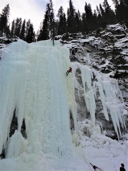 A climber rappels the Green Monster ice waterfall in Evan Thomas Creek