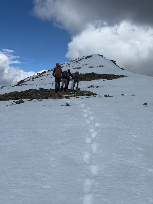 On the ridge, everyone marching in Sim's footsteps in the snow