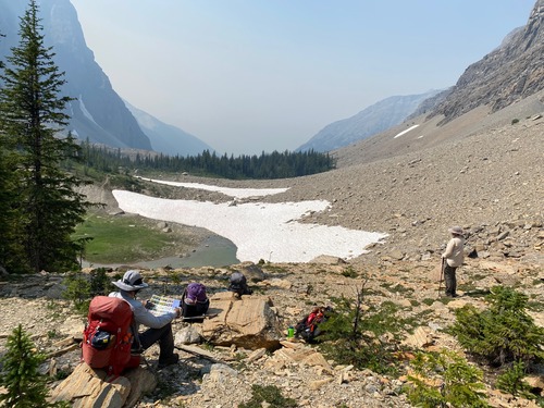Wolverine Pass - Evan studying the flower guide while Deb tries to see the Bugaboos through the smoke