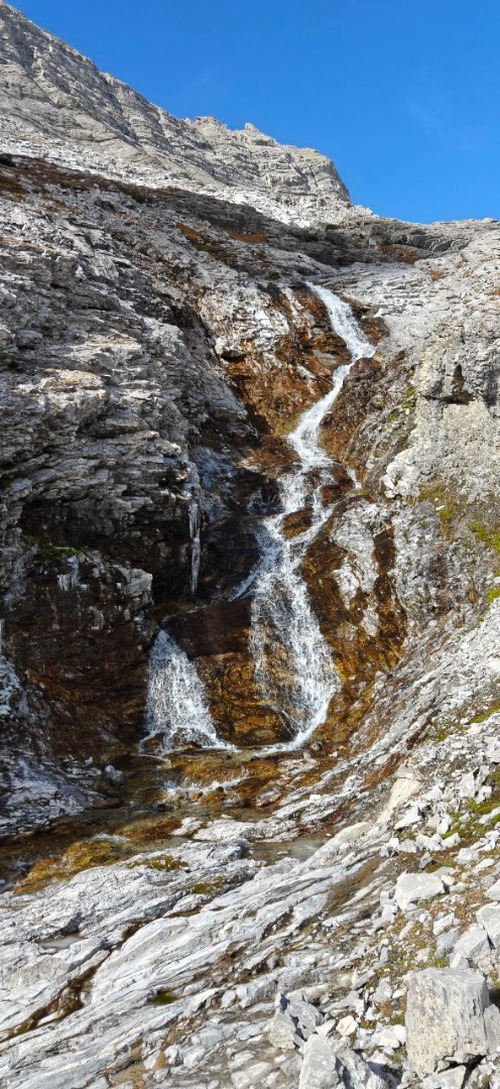 Waterfalls cascading through the rock formations and bright green moss