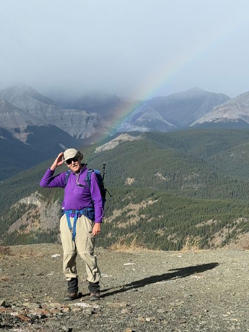 Hold onto your hat! Trip Coordinator Ron on the windy summit apparently getting zapped by the rainbow