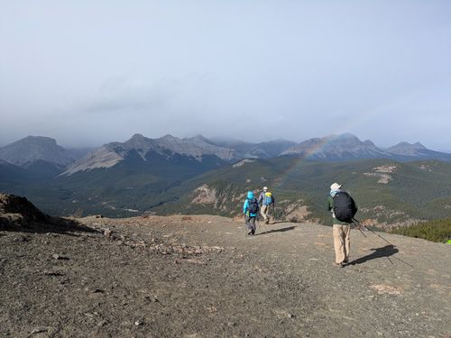 Crossing the windblown summit, rainbow still present
